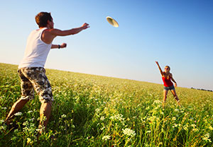 Image of field with two people throwing a frisbee